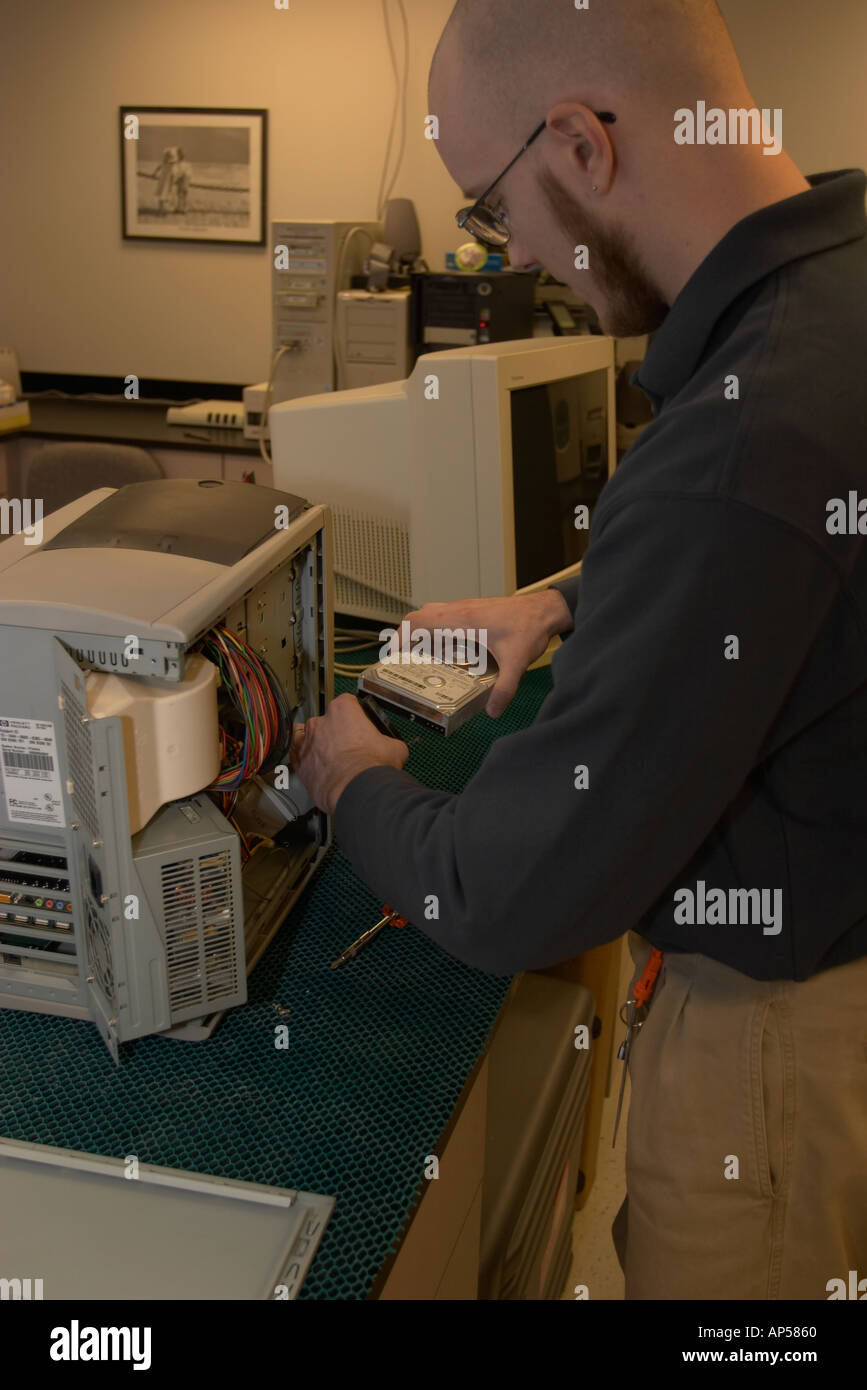 Forensics expert taking harddrive out of suspect s computer for further study Nebraska State Patrol Crime Lab Stock Photo