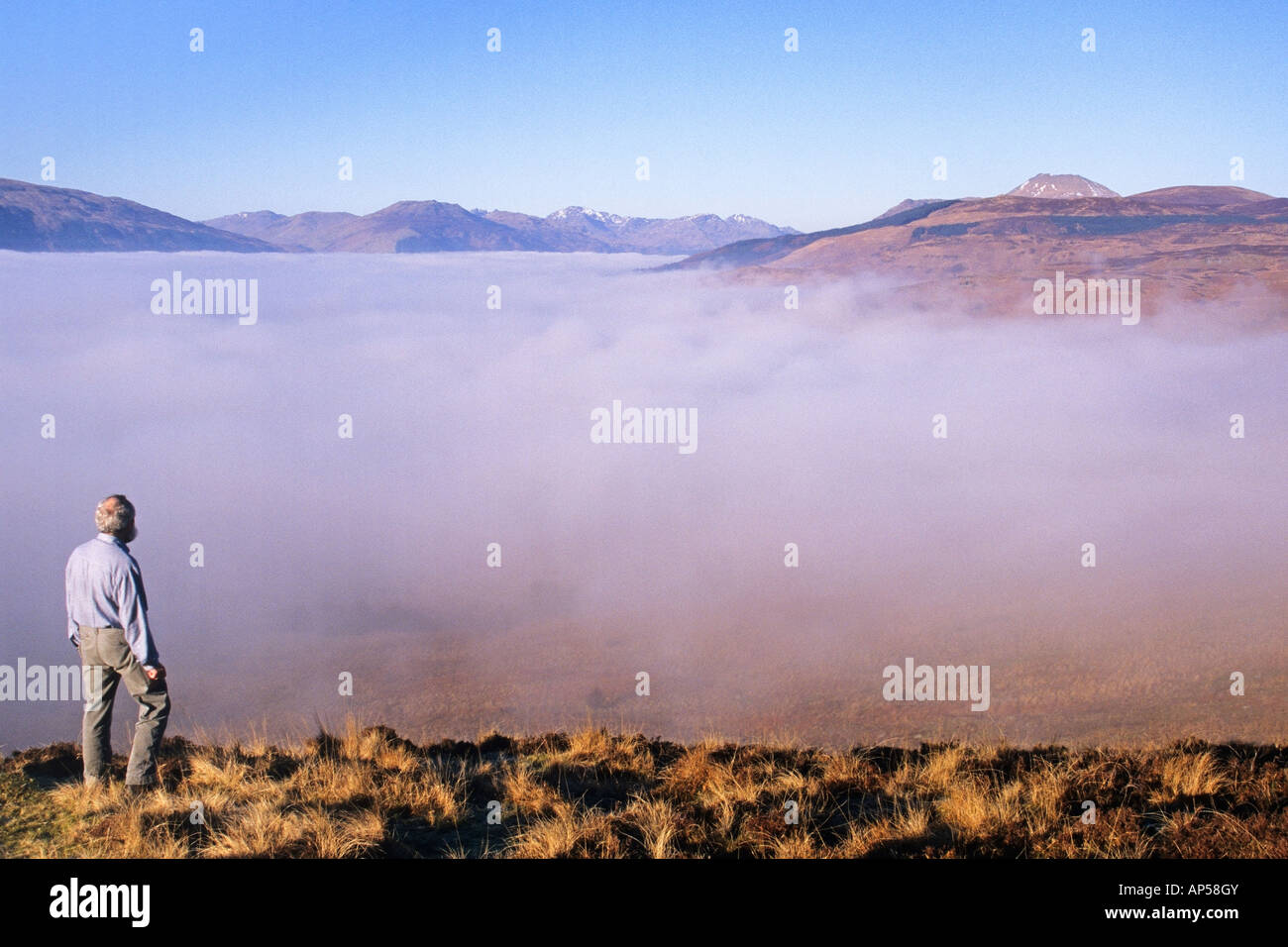 Looking down on a mist filled Loch Lomond from Conic Hill near Balmaha Ben Lomond is in the right background Stock Photo