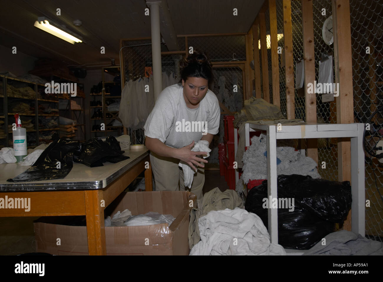 Female inmate sorting clean laundry in the inventory section Nebraska Correctional Center for Women  Stock Photo