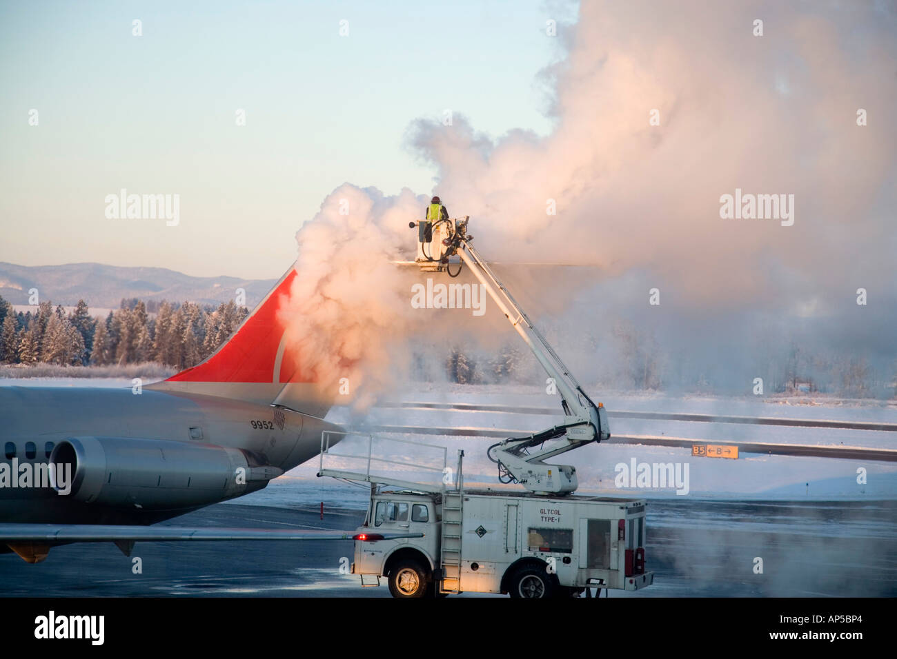 Spraying deicier on commercial airliner on cold winter day at Kalispell, Montana, USA Stock Photo