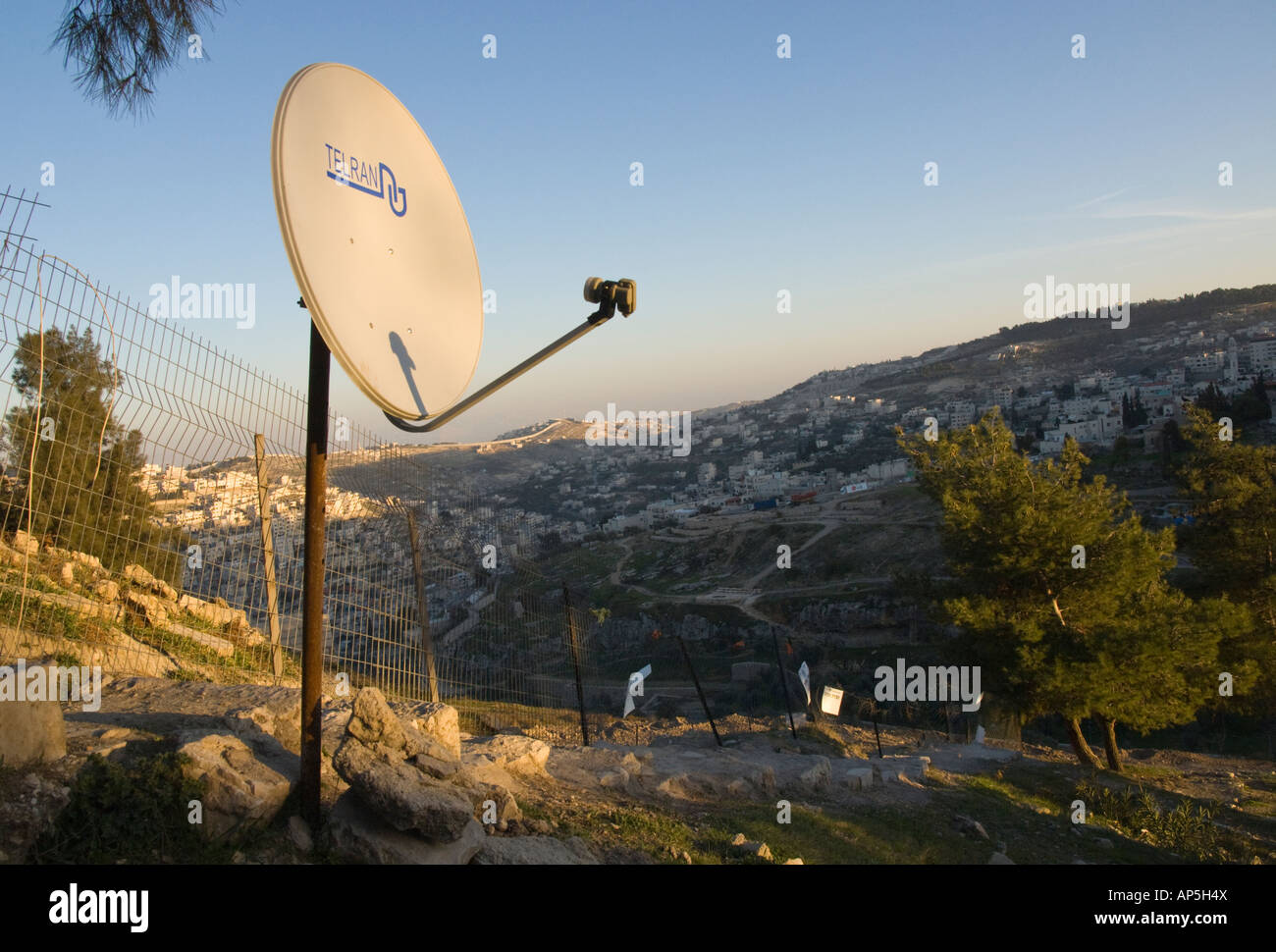 Israel Jerusalem village of Silwan Satelite TV dish on a rusted pole with typical Jerusalem hills landscape in bkgd Stock Photo