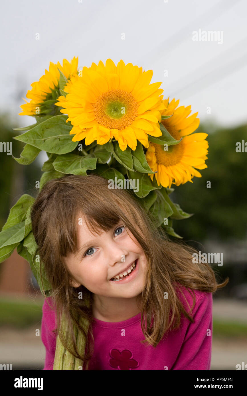 Smiling young girl holding a bunch of sunflowers Stock Photo - Alamy