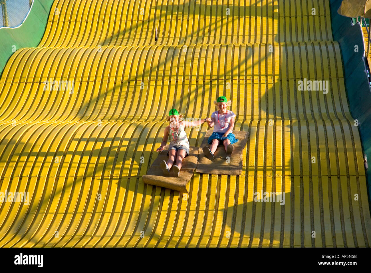 Children ride down a giant yellow slide at the Iowa state fair in Des