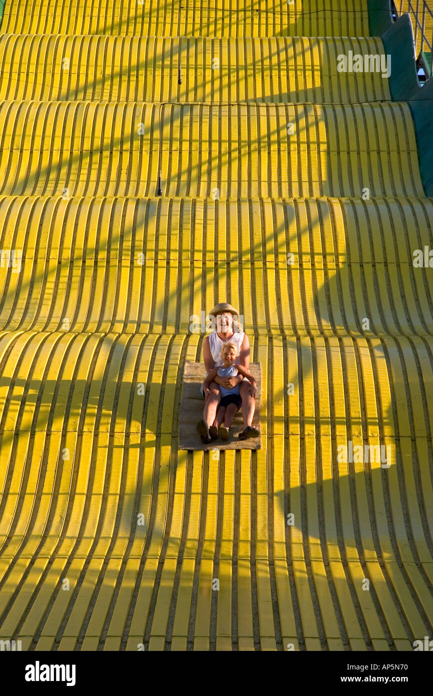 Mother and daughter ride down a giant yellow slide at the Iowa state