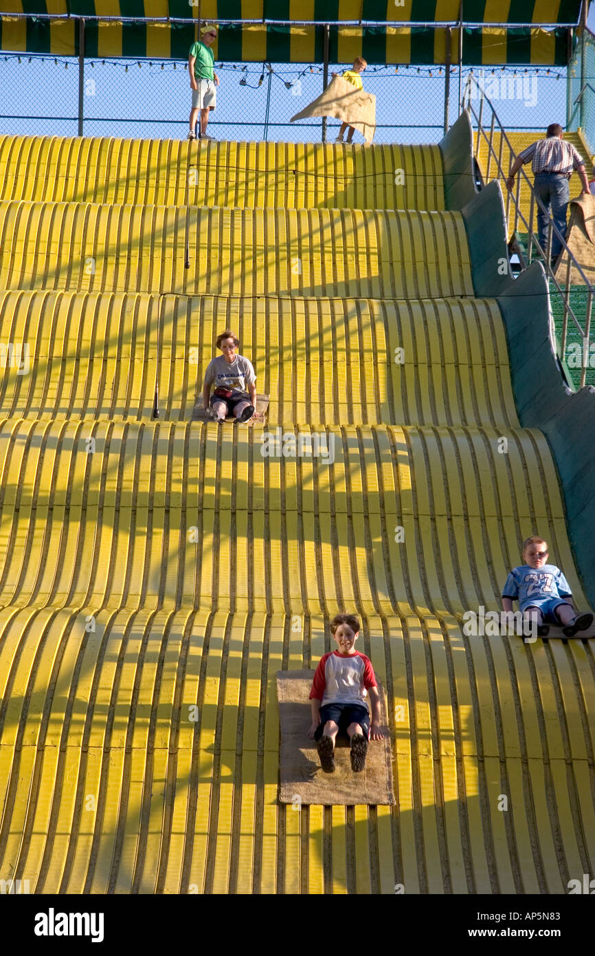 Children ride down a giant yellow slide at the Iowa state fair in Des