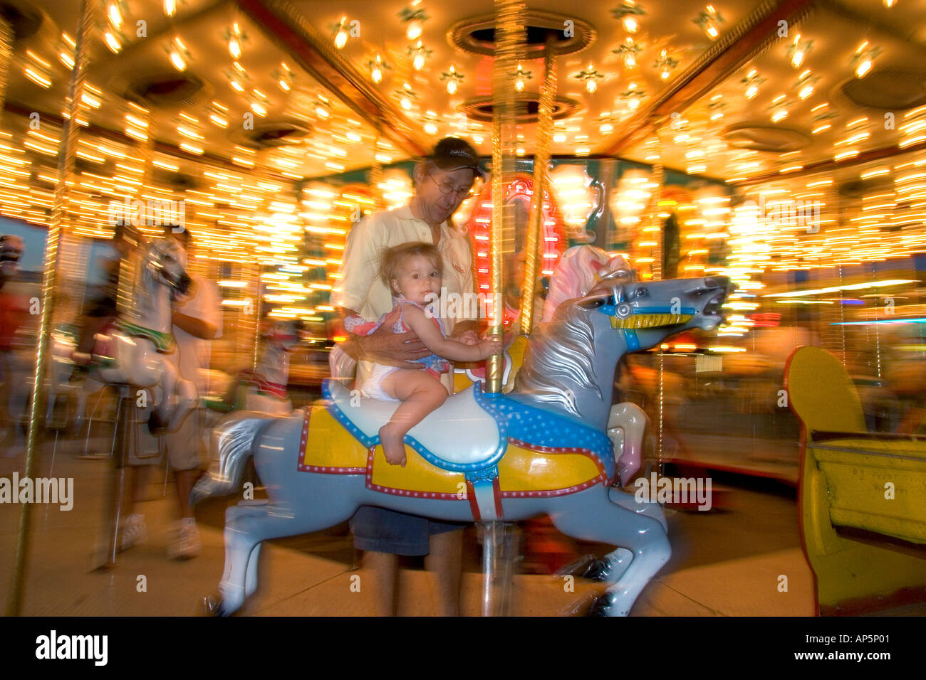 Children and adults ride a carousel at the Iowa state fair in Des