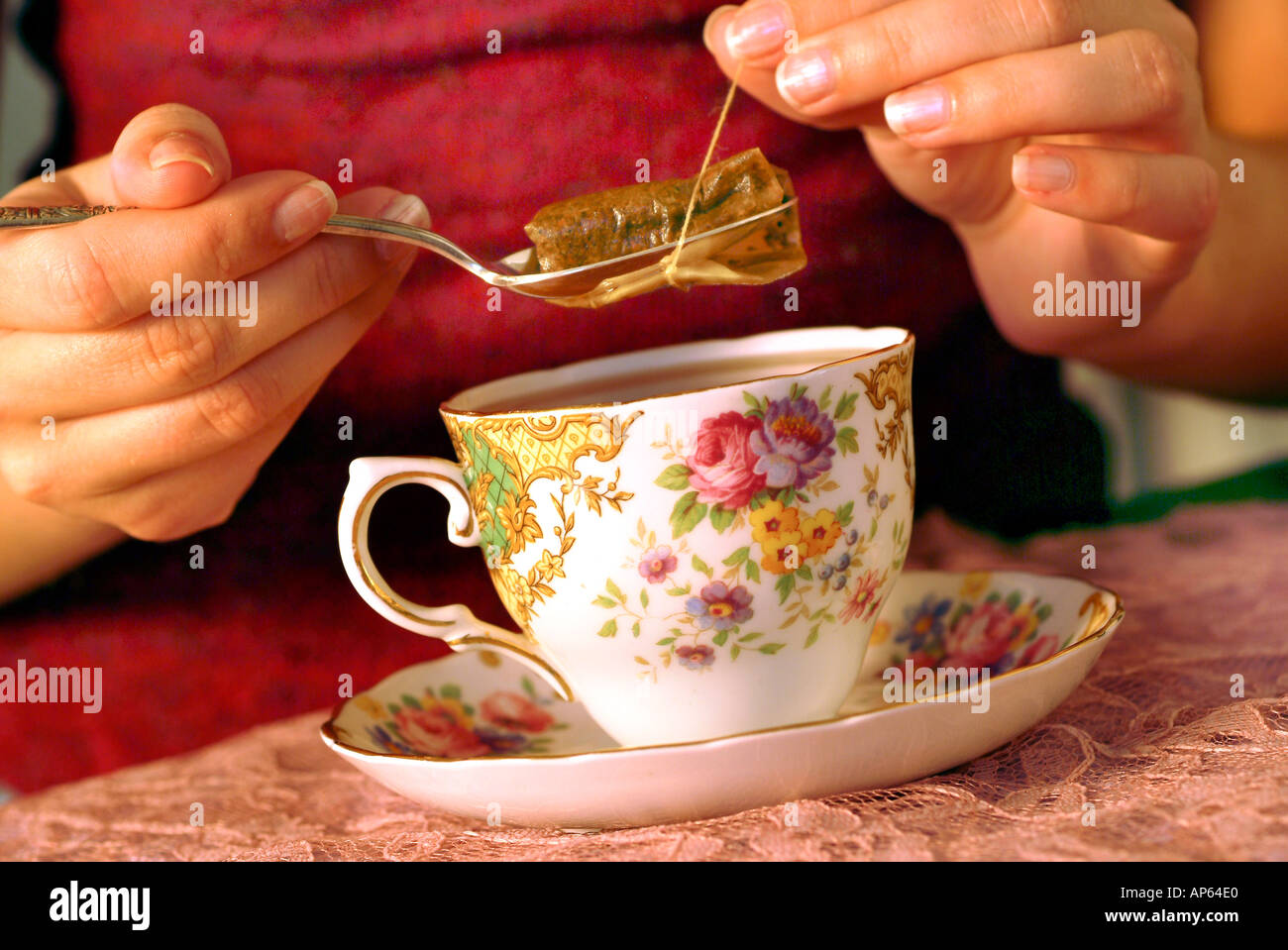 Hand with spoon Draining Tea bag into Cup of Tea Stock Photo Alamy