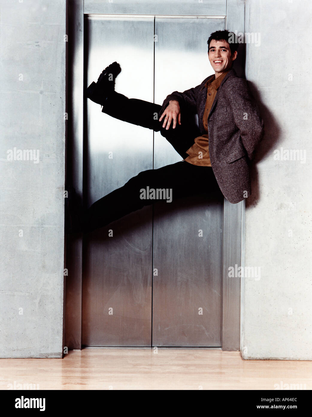 man hanging in elevator door Stock Photo