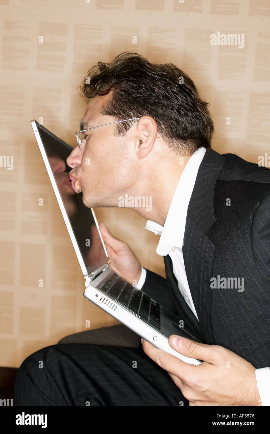 Businessman kissing his laptop computer Stock Photo - Alamy