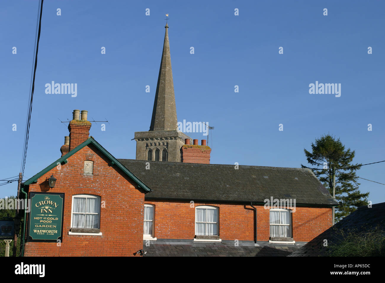 Pub at Bishops Cannings with the church spire in the background Stock Photo