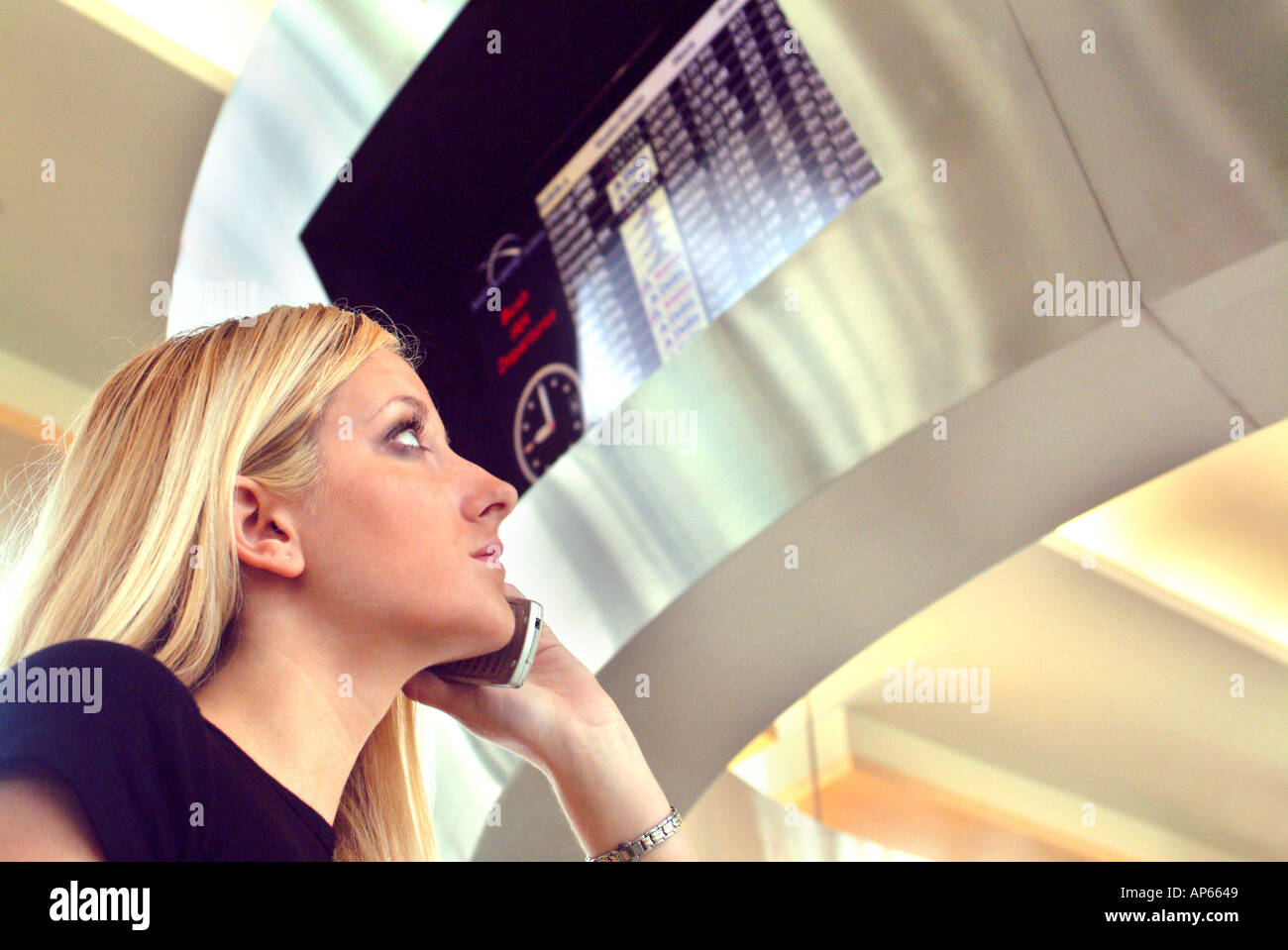 Young female businesswoman talking on cell phone at airport Stock Photo