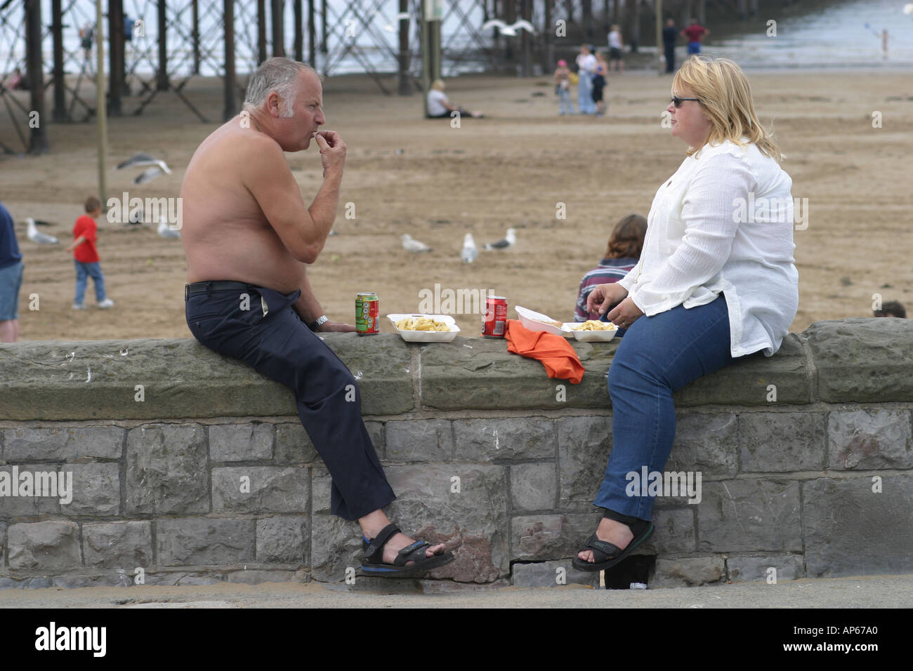 Couple enjoying fish and chips on the beach at Weston super Mare Stock Photo