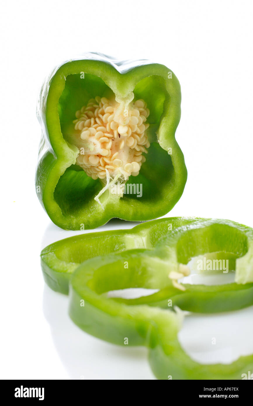 A fresh and tasty green pepper slices reflected on white background Shallow DOF and front blurred Stock Photo