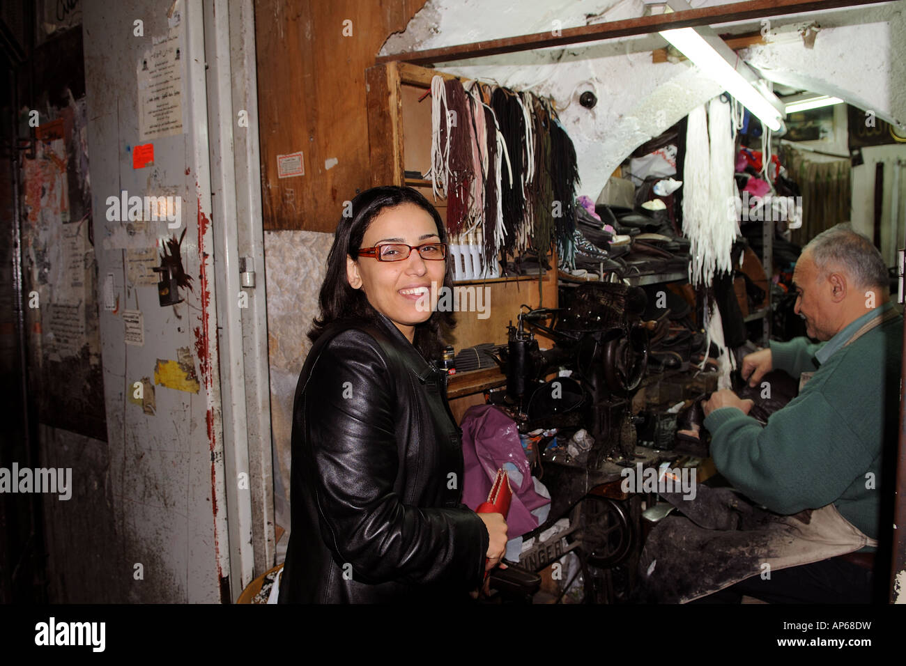 A young Arab woman visits the local tailor in the muslim quarter in the old city of Jerusalem. Stock Photo