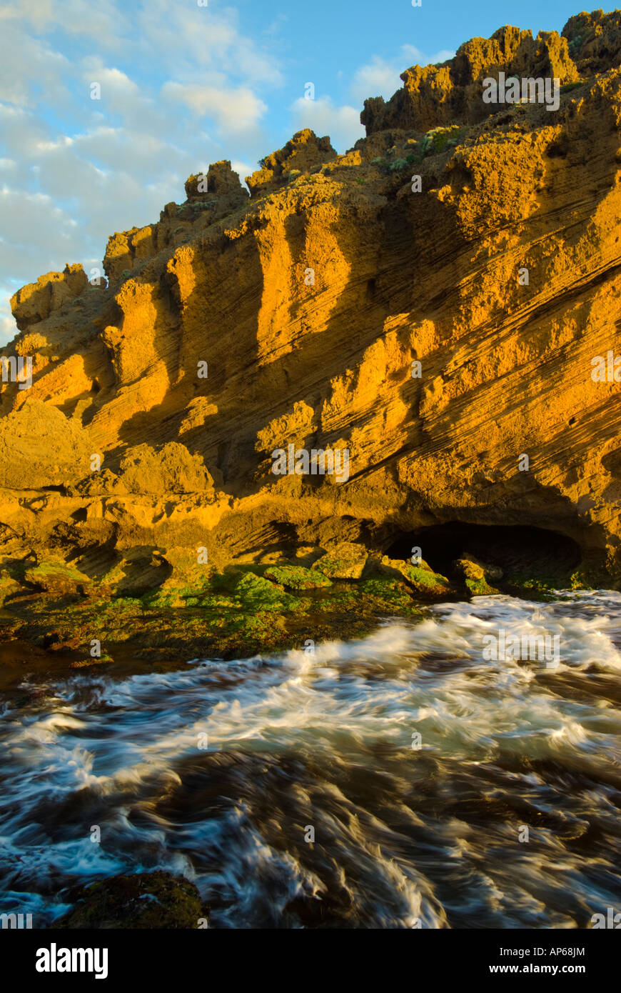 Waves dashing coastal cliffs in the glow of the evening light Stock ...