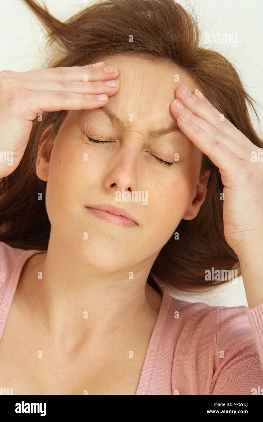 young woman holding her head as if she has a headache. Stock Photo