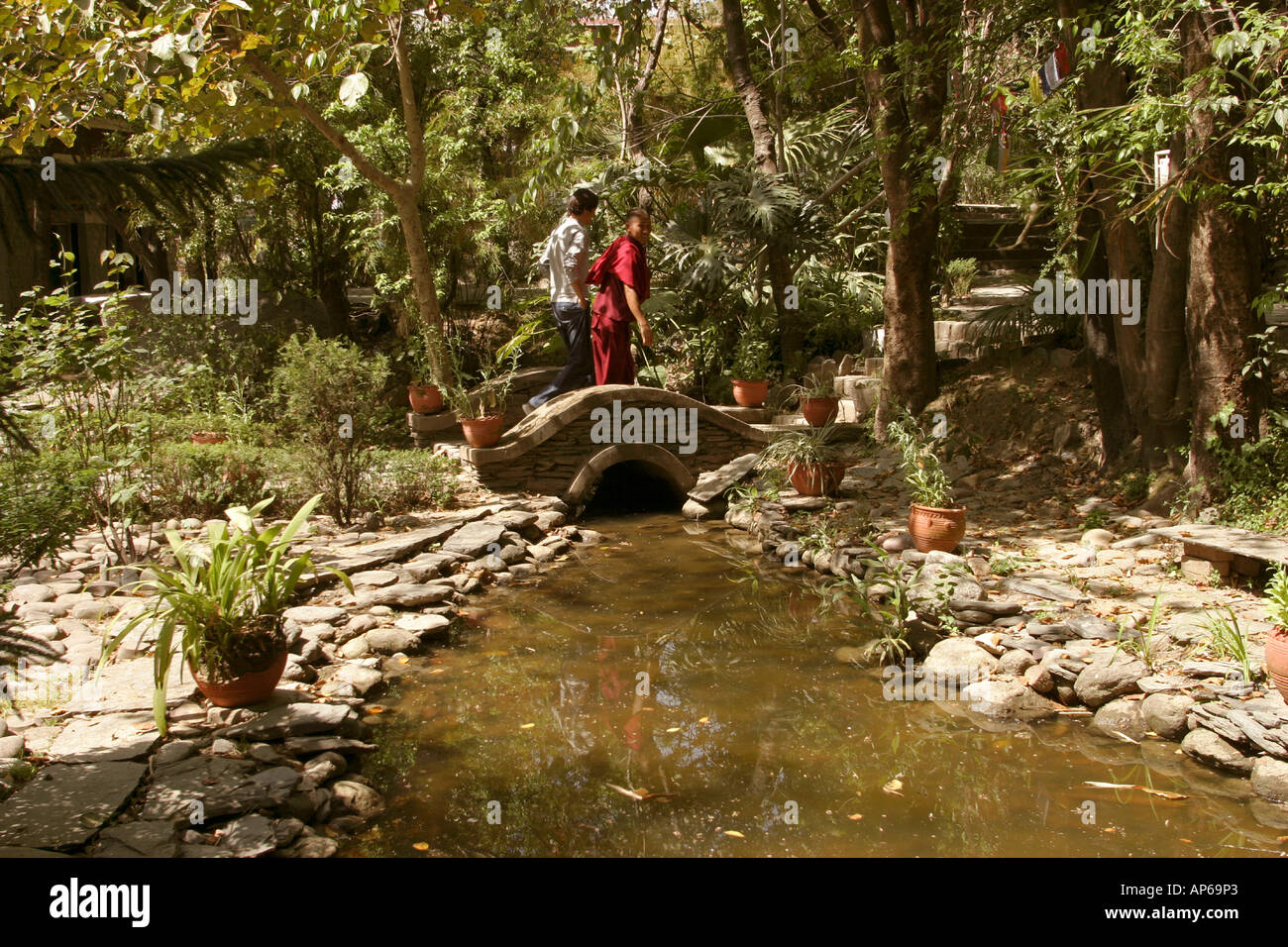 India Himachal Pradesh Sidhpur Norbulinka Institute monk and man walking through garden Stock Photo
