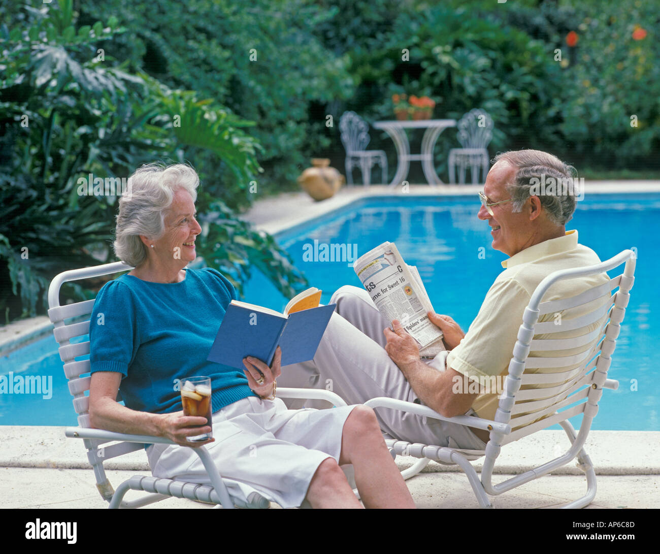 mature couple relaxing by pool Stock Photo