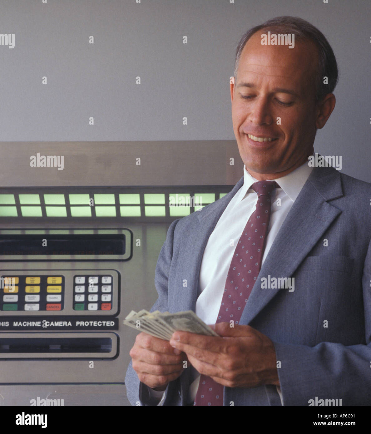 business man withdrawing money at an ATM machine Stock Photo