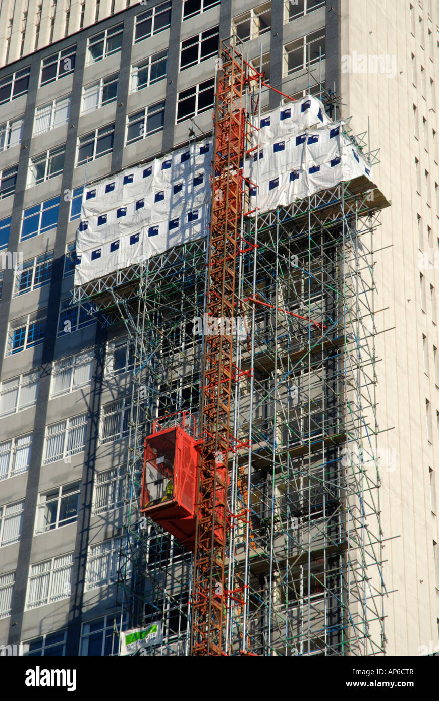 Tall scaffolding and elevator on side of seventies concrete