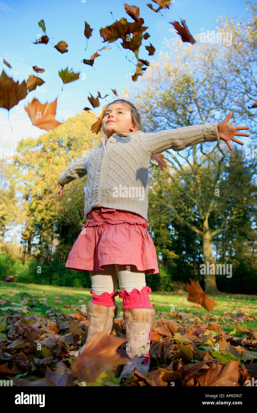 girl tossing autumn foliage Stock Photo