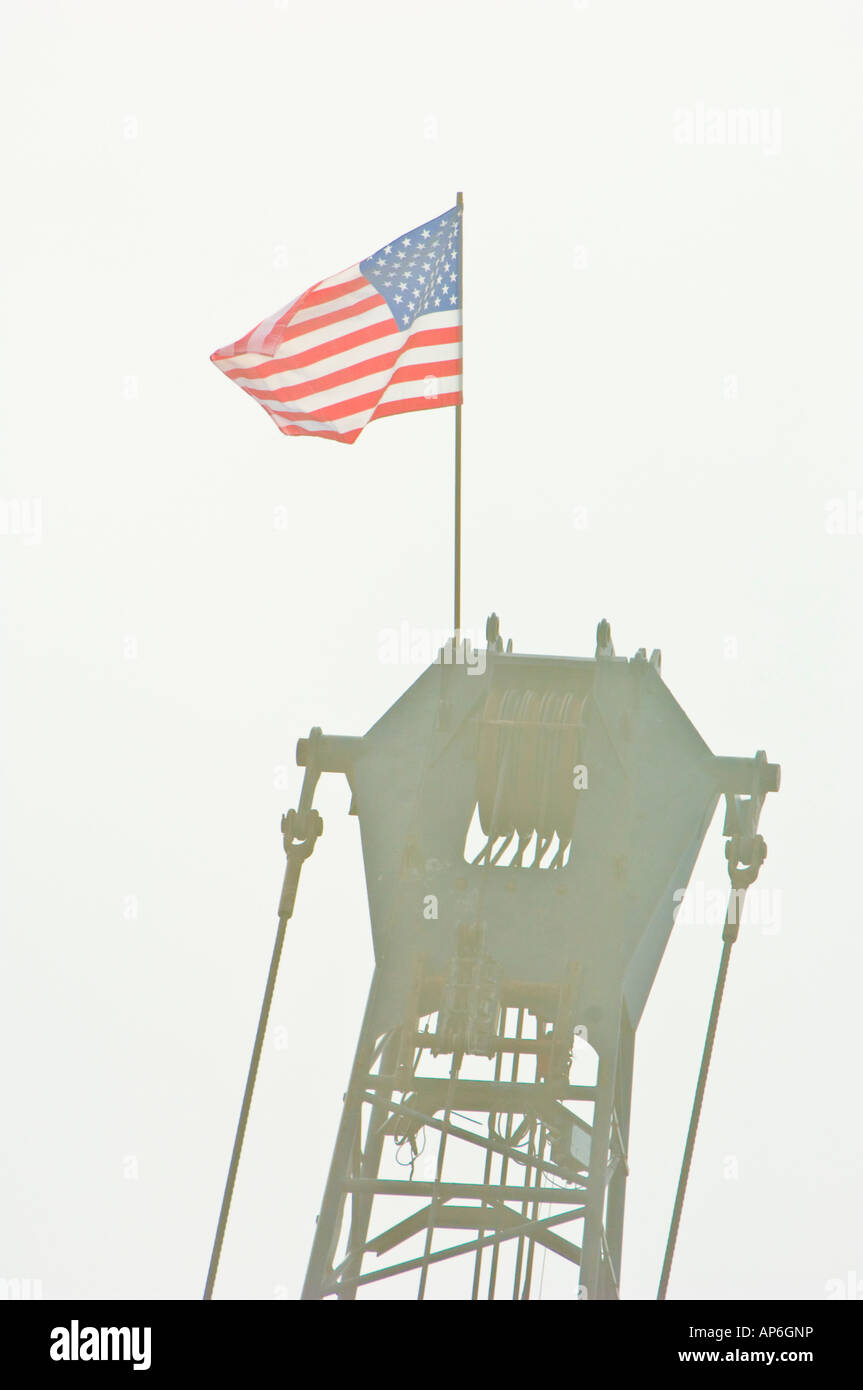 American flag on top of a crane boom crane flag high height top construction pride USA Stock Photo