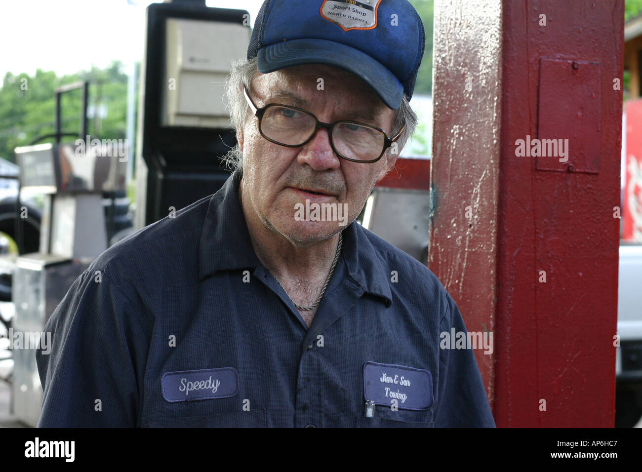 Gas station attendant older man with cap and uniform on in North