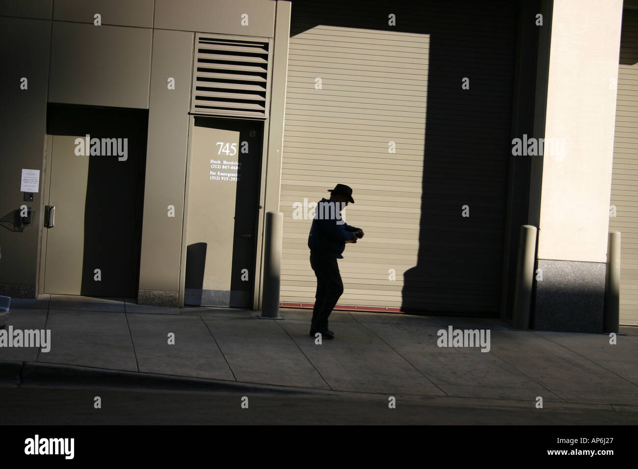 shadow of a man in cowboy hat in front of beige doors Stock Photo Alamy
