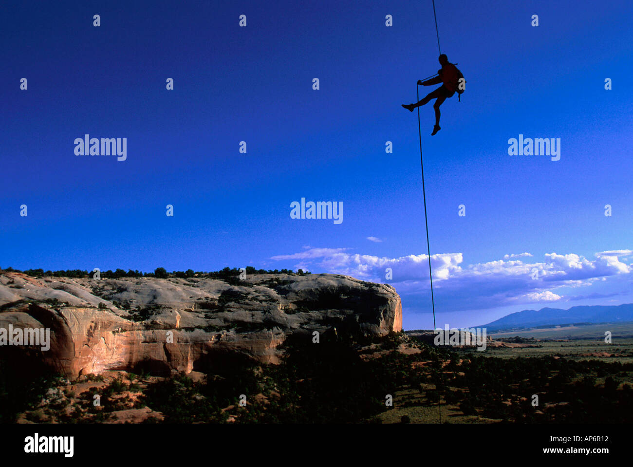 Man abseiling on rope in landscape of in Fisher Towers, Colorado River Waterway Near Castle Valley, Moab, Utah, USA Stock Photo