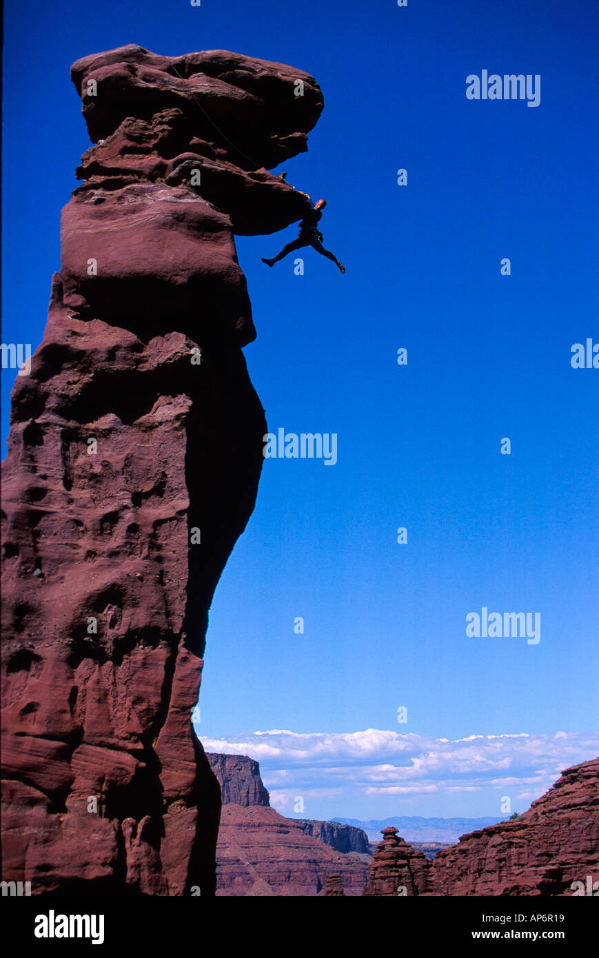 Rock climber in difficulty on overhang in Fisher Towers, Colorado River Waterway near Castle Valley in Moab, Utah, USA Stock Photo