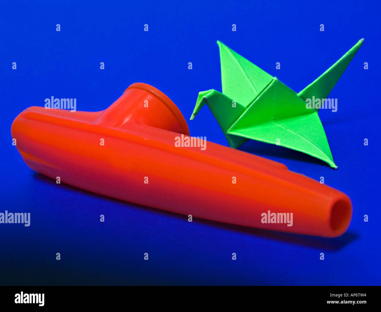 kazoo and a paper swan on blue background Stock Photo
