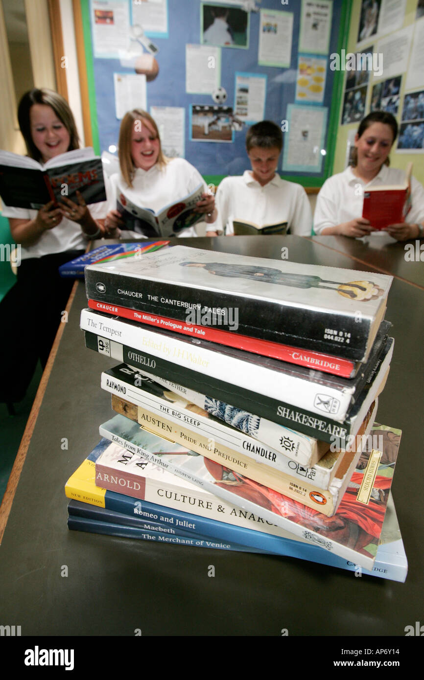 High school children reading with pile of set books in foreground South of England UK Stock Photo
