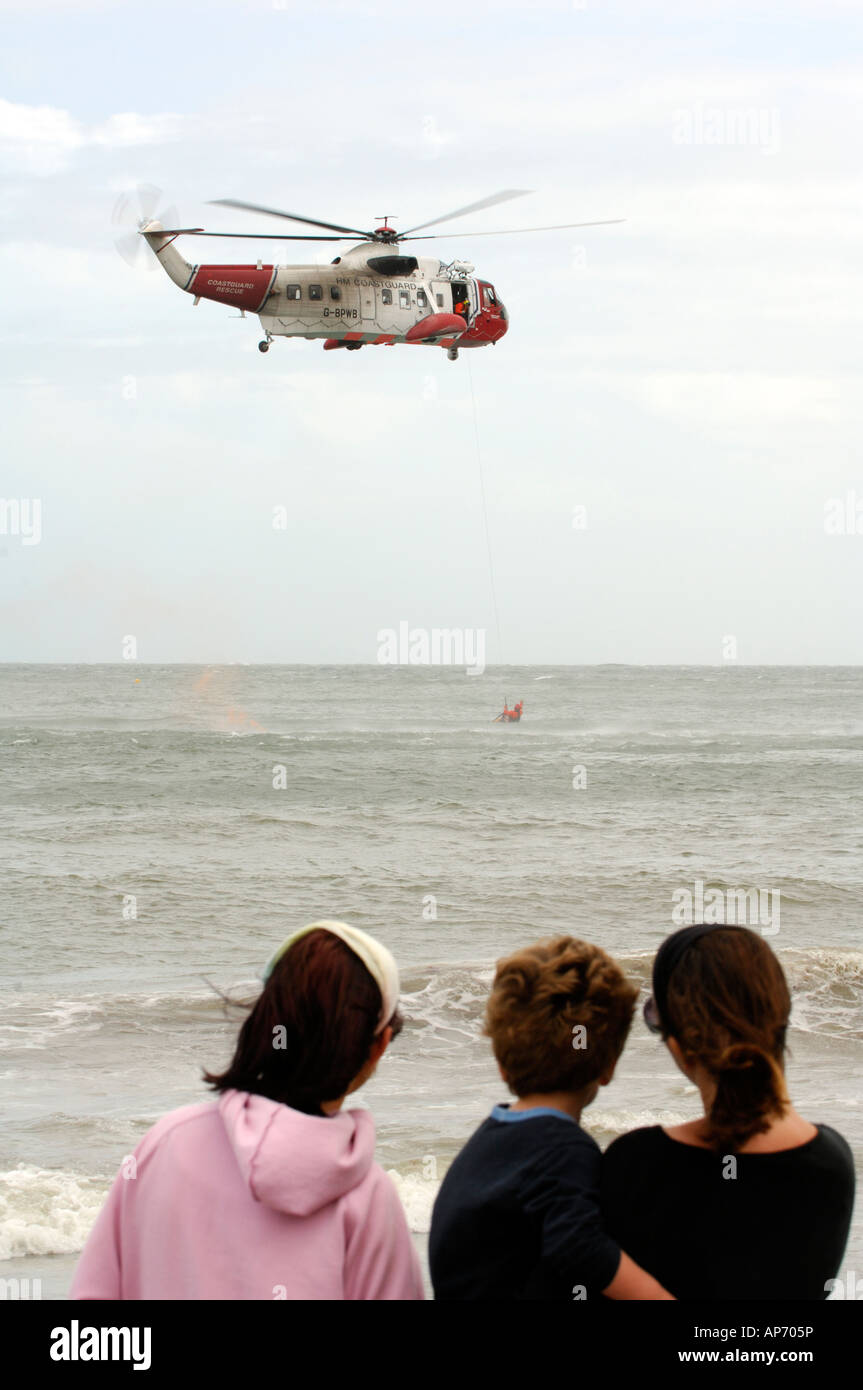 air sea rescue helicopter sea life saving rnli coastguard winch wire bravery resuers saving savers Stock Photo