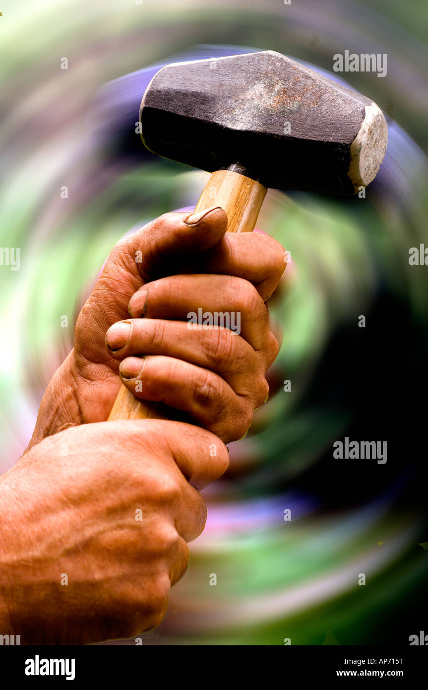 Hands grasping sledge hammer. Stock Photo