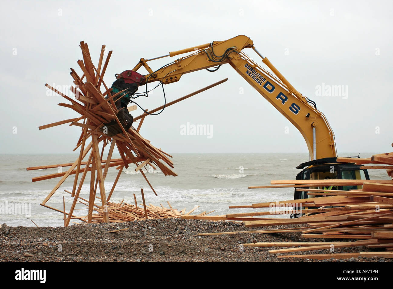 Komatsu PC210 LC crawler excavator clearing up wood from the wreckage of the cargo ship 'Ice Prince'. Worthing beach West Sussex Stock Photo