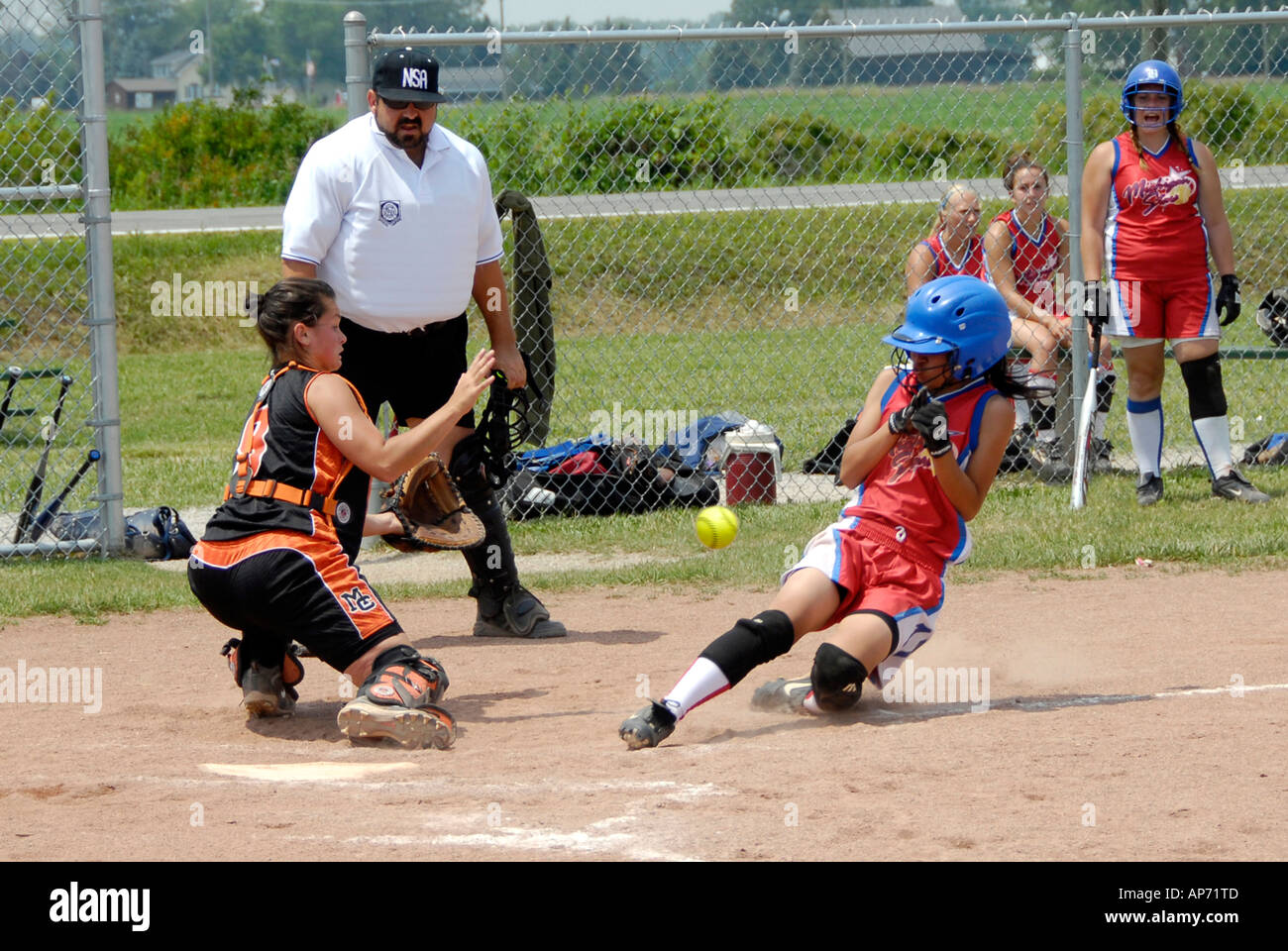 Baseball action girls playing softball running with play at home plate Stock Photo