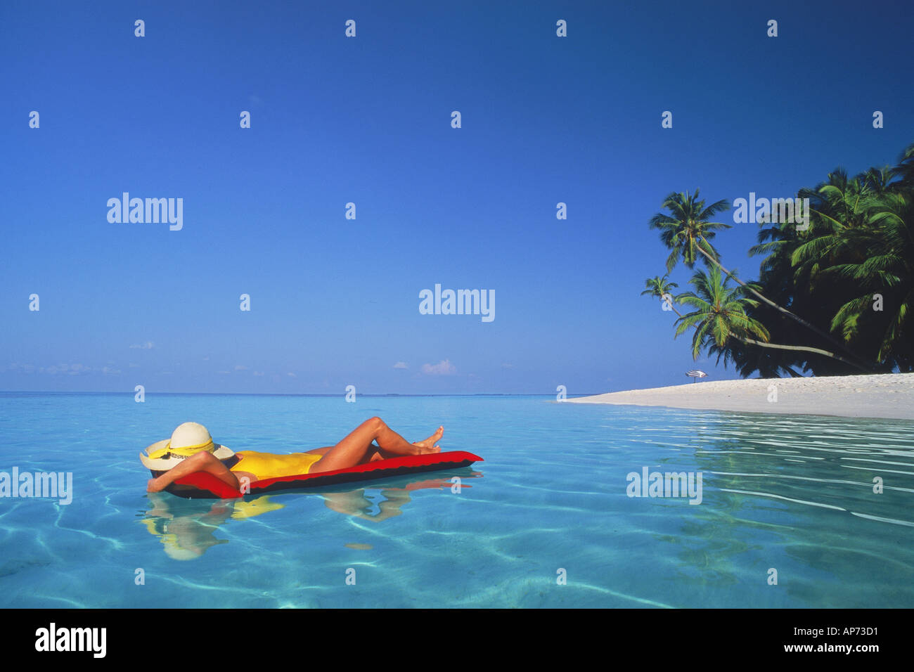 Woman relaxing on air mattress in tropical paradise Stock Photo