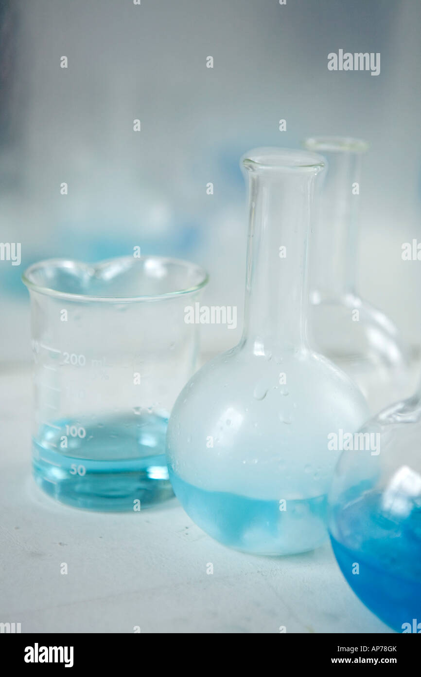 science research chemistry flasks and beakers with blue solution in