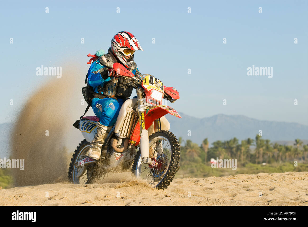 Male motorcycle rider riding on sandy beach in Baja California, Mexico Stock Photo