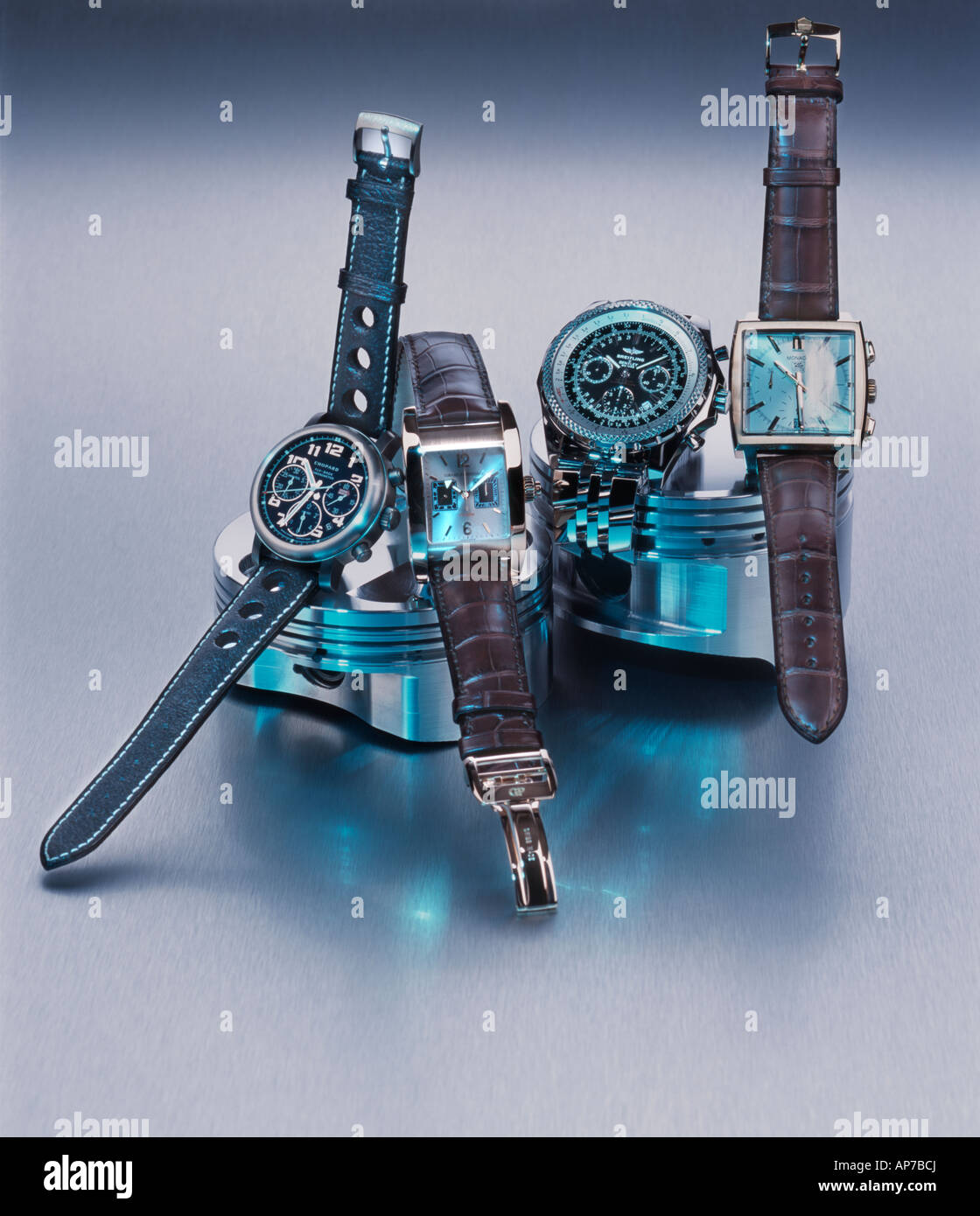 Four wristwatches on car piston heads Stock Photo