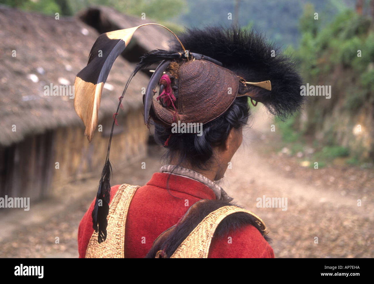 Formerly headhunters Hill Miri tribesmen wear traditional red jackets and animal fur hat and carry swords in scabbards Stock Photo