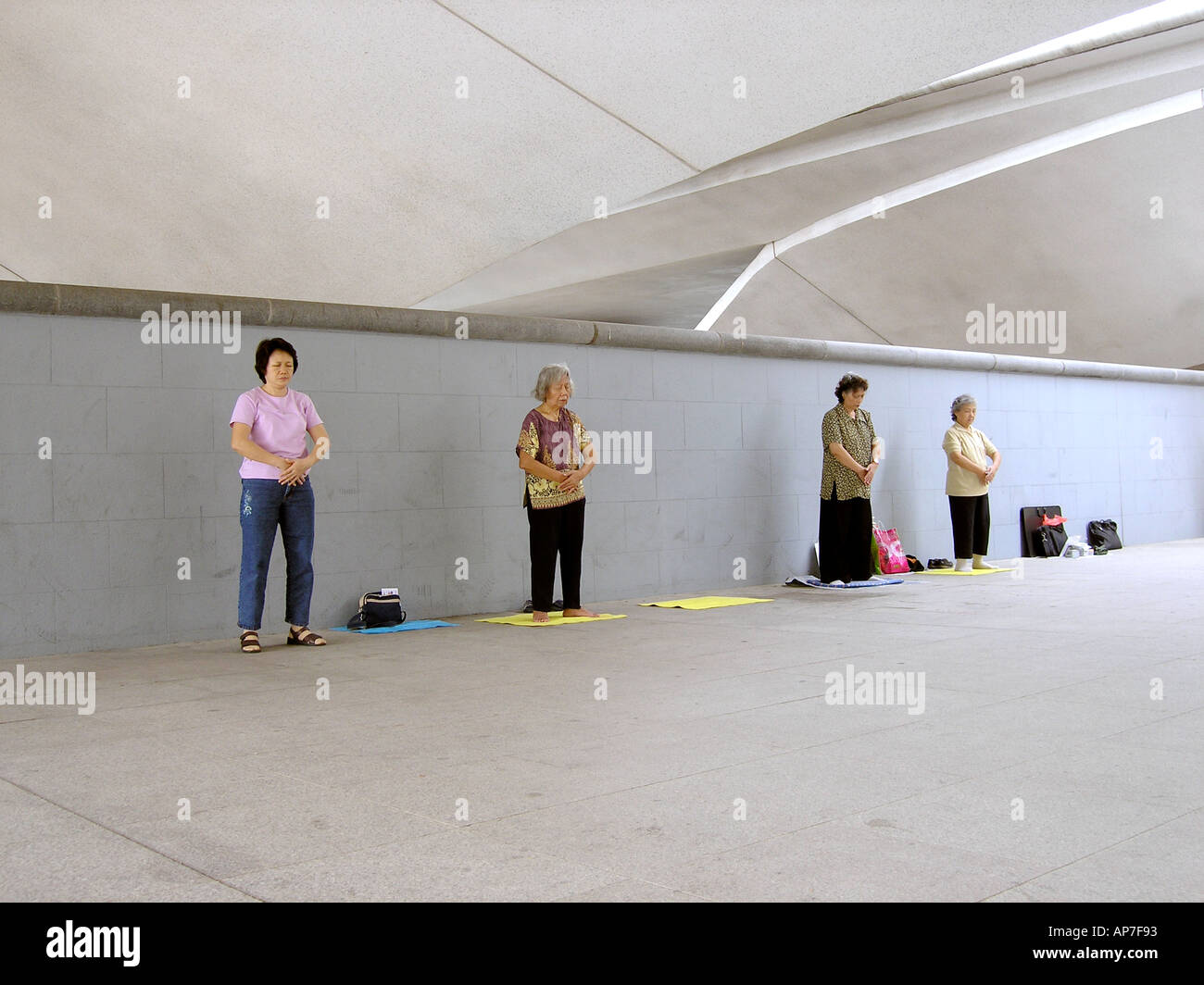 Women finishing Falun Gong exercises in underpass Singapore Stock Photo