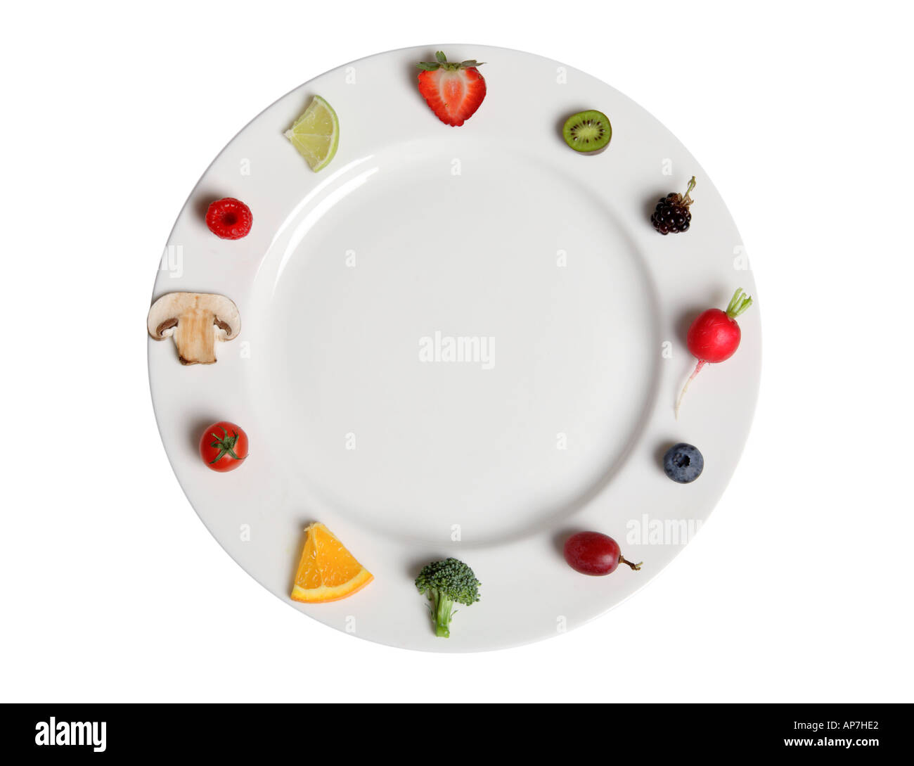 Fruits and vegetables arranged around the edge of plate Stock Photo