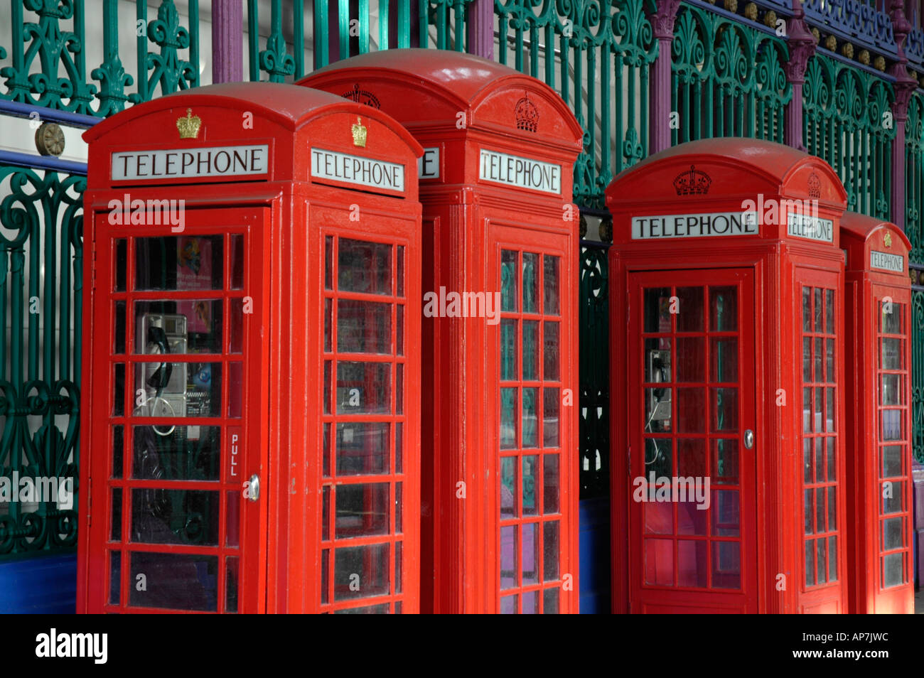 Four traditional British red telephone boxes against colourful