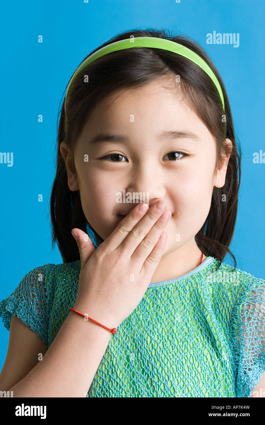 Girl with hand over her mouth Stock Photo - Alamy
