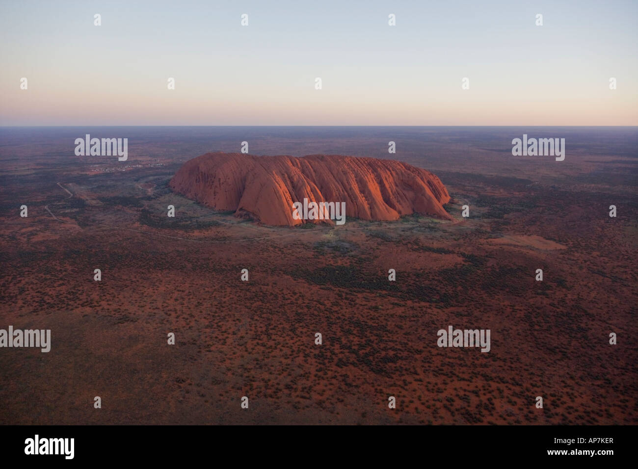 Aerial view of a glowing red Uluru (Ayres Rock) at Sunset Stock Photo