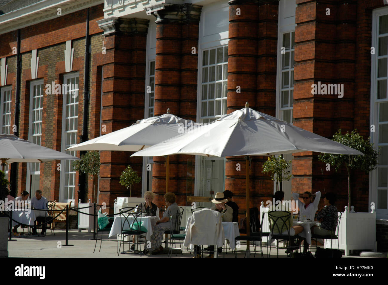 Customers sitting outside the Orangery restaurant in Kensington Palace Gardens London UK Stock Photo