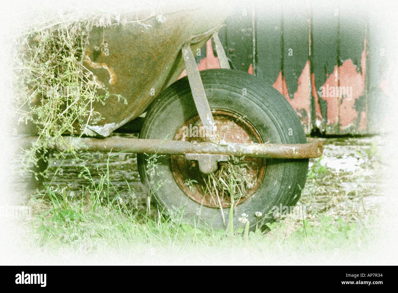 Hand tinted effect rustic scene with old wheelbarrow Stock Photo