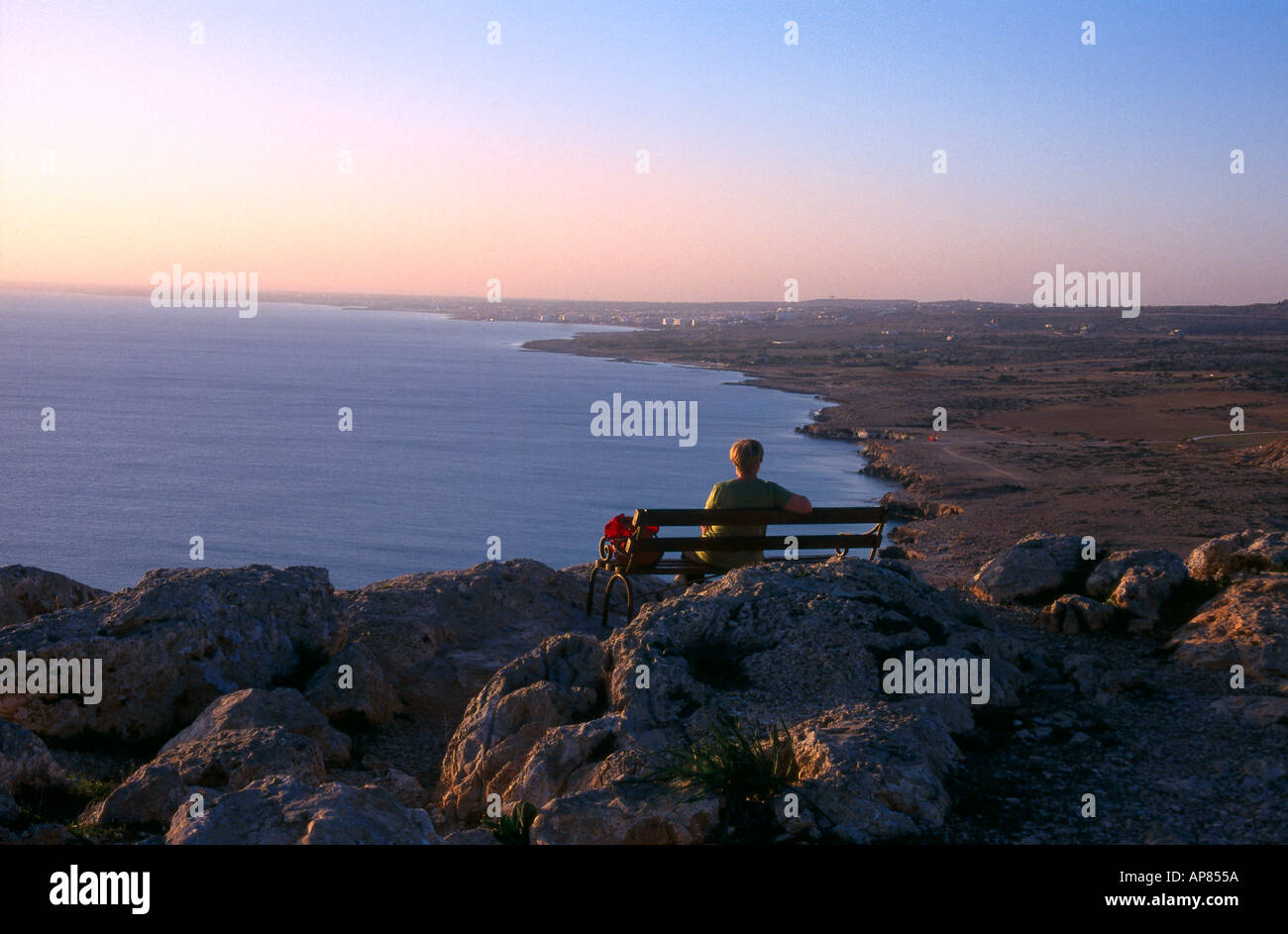 Person sitting on bench at coast, Cape Gkreko, Cyprus Stock Photo - Alamy