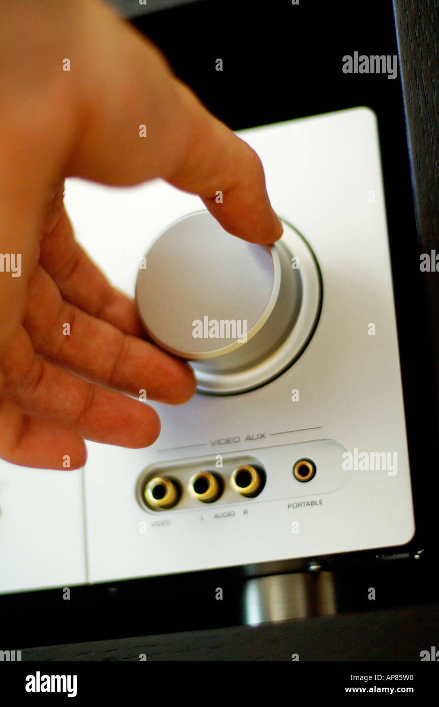Hand turning volume knob on stereo receiver Stock Photo Alamy